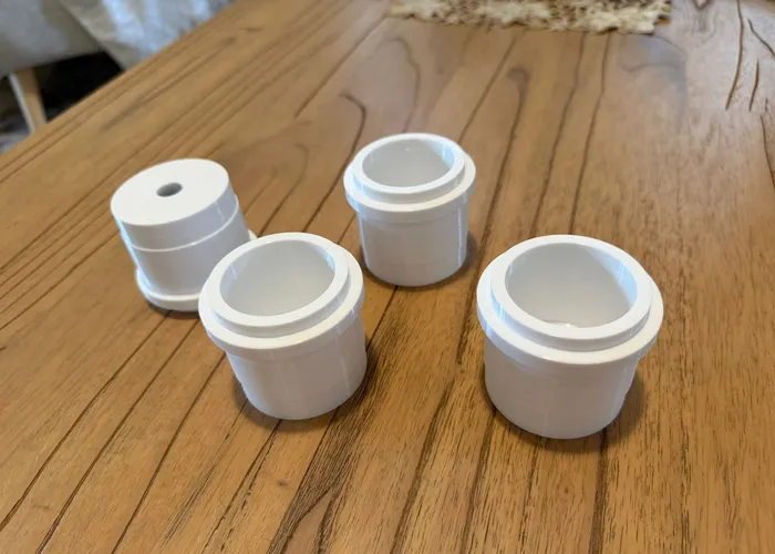 Four white custom 3D printed fittings on a timber table