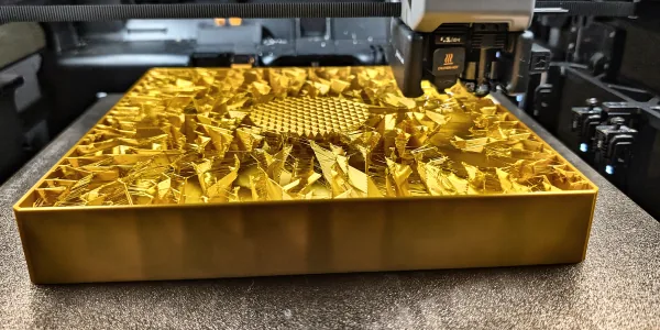 Gold 3D printed display tray with a faceted crystal texture